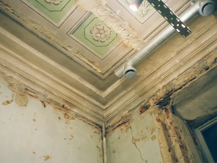 Plafond marqué par un dégât d'eau et une peinture écaillée