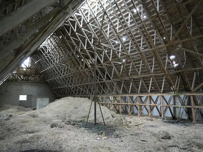 Grenier avec isolant soufflé et fermes de toit apparentes