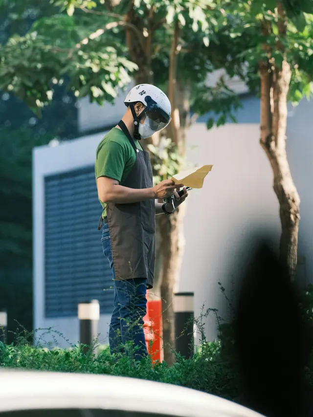 Inspecteur en bâtiment relevant ses observations devant une résidence